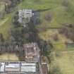 Oblique aerial view centred on the country house with the stables adjacent, taken from the NW.