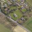 Oblique aerial view centred on the church with the tithe barn adjacent, taken from the NW.
