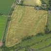 Oblique aerial view of the cropmarks of the unenclosed round houses and the barrow, taken from the SW.