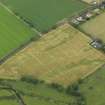 Oblique aerial view of the cropmarks of the unenclosed round houses and the barrow, taken from the SSE.