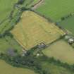 Oblique aerial view of the cropmarks of the unenclosed round houses and the barrow, taken from the E.