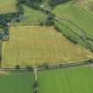 Oblique aerial view of the cropmarks of the unenclosed round houses and the barrow, taken from the NW.