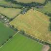 Oblique aerial view of the cropmarks of the unenclosed round houses and the barrow, taken from the WNW.