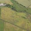 Oblique aerial view of the cropmarks of the barrow, unenclosed round houses, pits and rig, taken from the SSE.