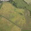 Oblique aerial view of the cropmarks of the barrow, unenclosed round houses, pits and rig, taken from the SE.