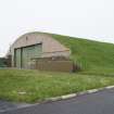 View from SSW of SW end of L type aircraft hangar showing grass covering on concrete roof.