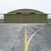 View from ENE of NE end of J type aircraft hangar with taxiway in the foreground.