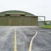 View from ENE of ENE end of J type aircraft hangar (E) showing taxiway.