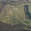 Oblique aerial view centred on the remains of the hut-circles and field system on Balnacoil Hill, taken from the W.