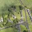 Oblique aerial view of Dalmeny centred on St Cuthbert's Church, taken from the W.