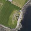 Oblique aerial view of the excavated settlement, broch and lairds house at Jarlshof, taken from the WNW.