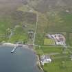 Oblique aerial view of Mid Yell centred on the pier, looking S.