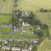 Oblique aerial view of Dalmeny centred on St Cuthbert's Church, taken from the SE.