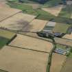 General oblique aerial view of the cropmarks of the rig, trackway and ring ditch and Mungoswells Farm, taken from the NW.