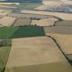 General oblique aerial view of the cropmarks of the rig, trackway and ring ditch and Mungoswells Farm, taken from the NNW.