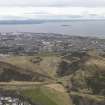 General oblique aerial view of the city (Leith) and the park centred on Salisbury Crags, taken from the SE.