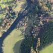 Oblique aerial view centred on the excavations of the round house and other archaeological features, taken from the NNW.