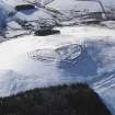 General oblique aerial view of fort, settlement, cultivation terraces and rig and furow under snow, looking to W.