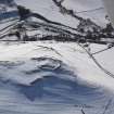 General oblique aerial view of scooped settlement, settlement and cultivation terraces under snow, looking to WSW.