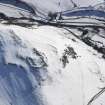 General oblique aerial view of scooped settlement and settlement  under snow, looking to S.