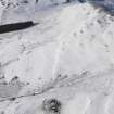 Oblique aerial view of the scooped settlement and rig and furrow under snow, looking to NW.