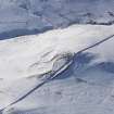 Oblique aerial view of settlement and rig under snow, looking to W.