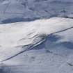 Oblique aerial view of settlement and rig under snow, looking to W.