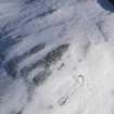 Oblique aerial view of palisaded enclosure, settlement and cord rig under snow, looking to SE.