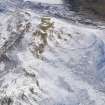 Oblique aerial view of White Meldon fort and cairn under snow, looking SW.