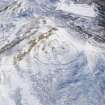 Oblique aerial view of White Meldon fort and cairn under snow, looking S.