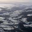 General oblique aerial view of Aberfeldy under snow with Loch Tay in the distance, looking SW.