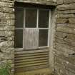 Detail or original window at ground level showing louvered section to allow ventilation.