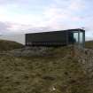 General view of the An Turas waiting room, Gott Bay, Tiree, taken from the North. This image shows the dry stone dyke and rocks that the structure straddles.