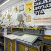 View of typesetting workbenches, wallspace and racks and drawered cabinets for type within the case room of the Foulis Building