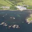 Oblique aerial view of Lagavulin Distillery and the remains of Dunyvaig Castle, taken from the SSE.