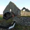 General view of Cornaigmore Mill, Tiree, taken from the North-West. The image shows the water wheel to Northen gable of the mill.