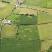 Oblique aerial view of the parchmarks of the rectangular enclosure with Redkirk farmstead adjacent, taken from the SSE.