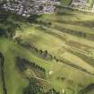 Oblique aerial view of the parchmarks of the barrow on Muir of Ord golf course, looking to the NE.