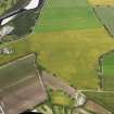 Oblique aerial view of the cropmarks of the rig and field boundary, looking NW.