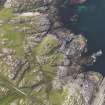 Oblique aerial view of the remains of Dun Mor Vaul broch on the Island of Tiree, taken from the SE.
