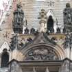 View of two royal figures, at top of clocktower above main door.