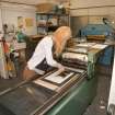 View of student working at a press within the case room of the Foulis Building