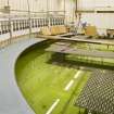 Interior. Curved wave tank building. View of tank with its modular work platforms, signal processing receivers (left) and 'beaches' on the right