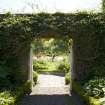 Walled garden.  View looking south through gate in wall to east of house.