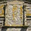 Detail of armorial panel above arched entrance to courtyard, view from W