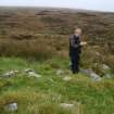 Mr Stratford Halliday, RCAHMS, recording the cairn and enclosure.
