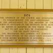 Interior. Detail view of commemorative plaque on wall of staircase to gallery.