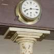 Interior. Detail of column capital and gallery clock.