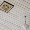 Interior. Detail of ceiling ventilator and light fitting on timber boarded church ceiling