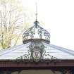Detail of roof with finial and iron work with coat of arms